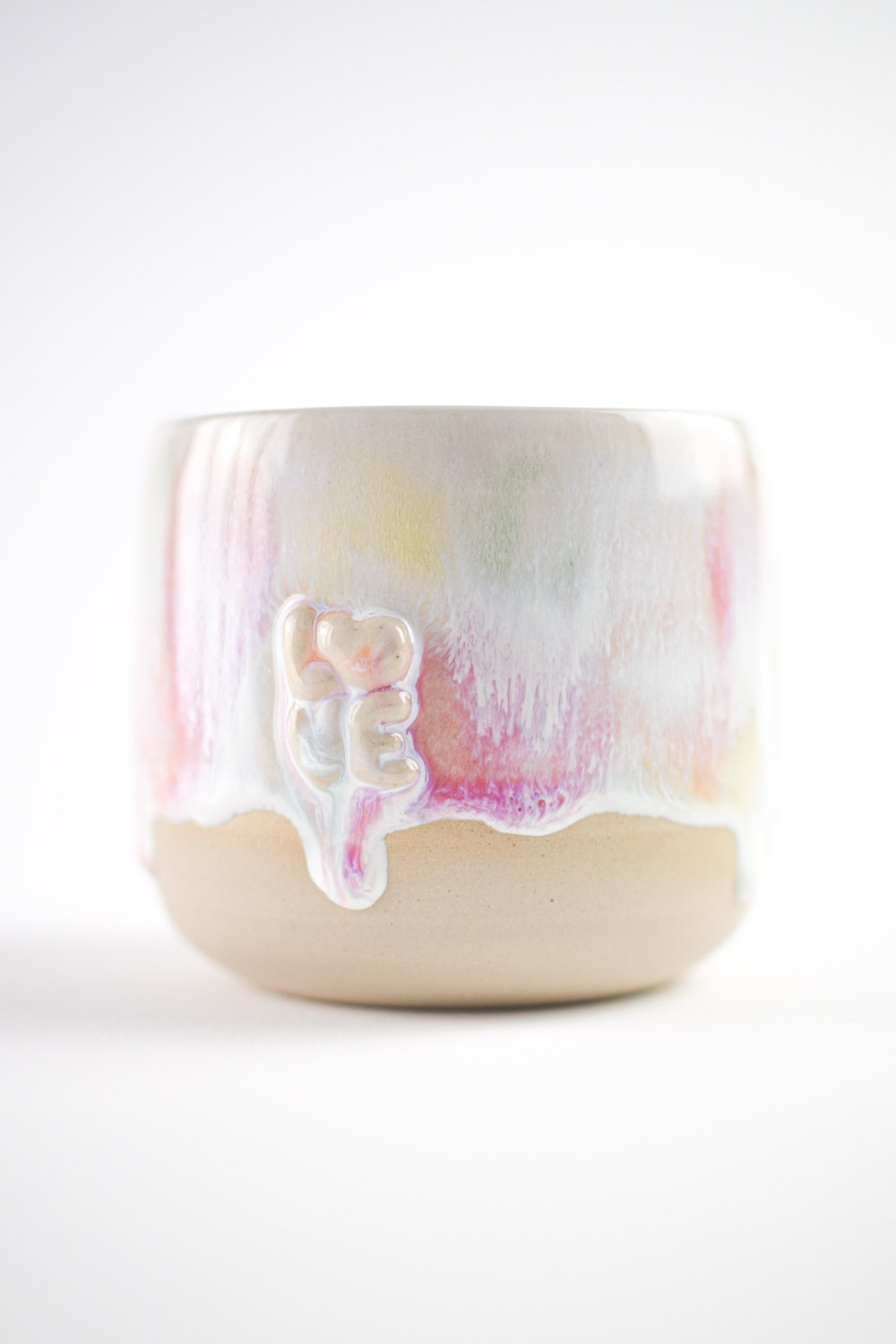 Handgefertigte Tasse mit erhabenem "love" Schriftzug und bunter Glasur