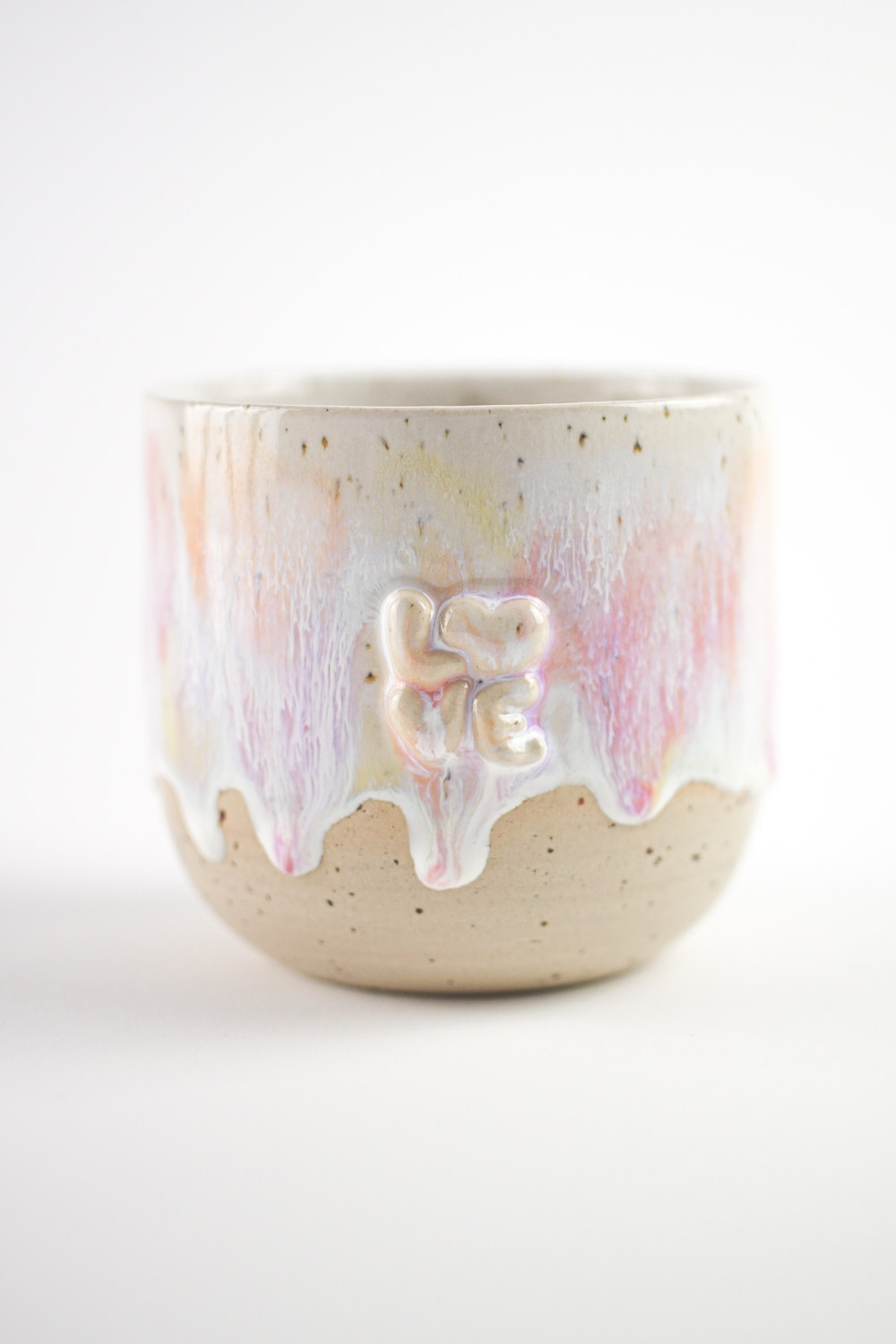 Handgefertigte Tasse mit erhabenem "love" Schriftzug und bunter Glasur