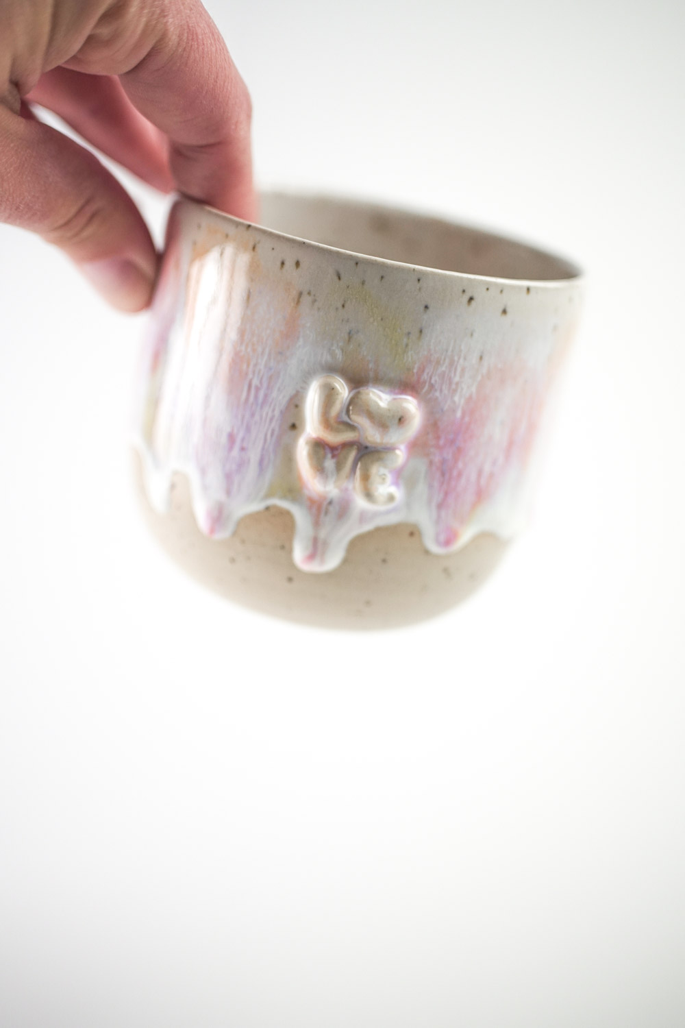 Handgefertigte Tasse mit erhabenem "love" Schriftzug und bunter Glasur