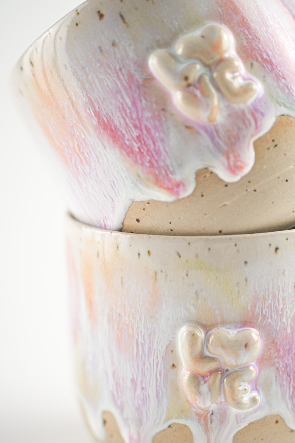 Handgefertigte Tasse mit erhabenem "love" Schriftzug und bunter Glasur